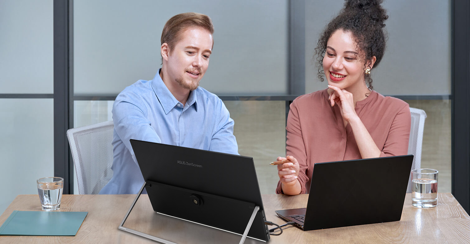 Kollegen diskutieren in einer Bürogemeinschaft mit Laptop und ZenScreen MB29CF